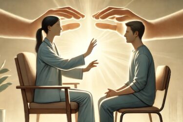 A woman and a man sit facing each other, both with their hands raised towards a bright, glowing light between them. Large, ethereal hands hover above, enhancing the glow. A small plant is visible to the side. The scene suggests healing or connection.