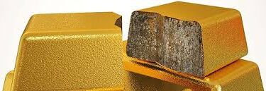Several gold bars are stacked, but one bar is cut open to reveal a gray, rough interior, indicating that it is not solid gold.