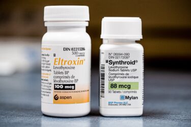 Two prescription pill bottles labeled Eltroxin (100 mcg) and Synthroid (88 mcg), both containing levothyroxine tablets, are placed side by side on a gray surface.
