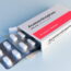An open box of acetaminophen 500 mg tablets with two blister packs, each containing white oval pills. The box is labeled "24 tablets / oral use" and "extra strength" on a light blue background.