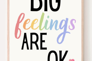 A framed sign with the words "BIG feelings ARE OK" in bold black and pastel rainbow letters, with a pink heart next to "OK" on a white background.