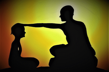 Silhouette of an adult sitting cross-legged and placing a hand on a child's head, against a yellow and orange gradient background suggestive of a sunrise or sunset.