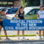 Four people stand on a sidewalk holding a large blue banner that reads, "Medical Freedom Is The New Civil Rights Movement." Two women wear shirts with protest slogans. Cars are parked in the background.