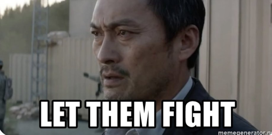 A serious-looking man stands outdoors with the text "LET THEM FIGHT" in bold letters at the bottom of the image.