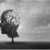 A tree shaped like a human head stands in a field; its branches lose leaves that are blowing away, symbolizing memory loss or fading thoughts under a cloudy sky.