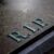A close-up of a weathered gravestone with the letters "R.I.P." engraved on its surface, symbolizing rest in peace. The stone appears aged and has a slightly damp texture.