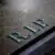 A close-up of a weathered gravestone with the letters "R.I.P." engraved on its surface, symbolizing rest in peace. The stone appears aged and has a slightly damp texture.