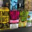 Colorful boxes of Lemon Twist and Melon Twist e-liquid are displayed on a store shelf. Warning labels and flavors are visible. Other vape products are partially visible on either side.