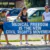 Three women holding a blue banner that reads, “MEDICAL FREEDOM IS THE NEW CIVIL RIGHTS MOVEMENT.”.